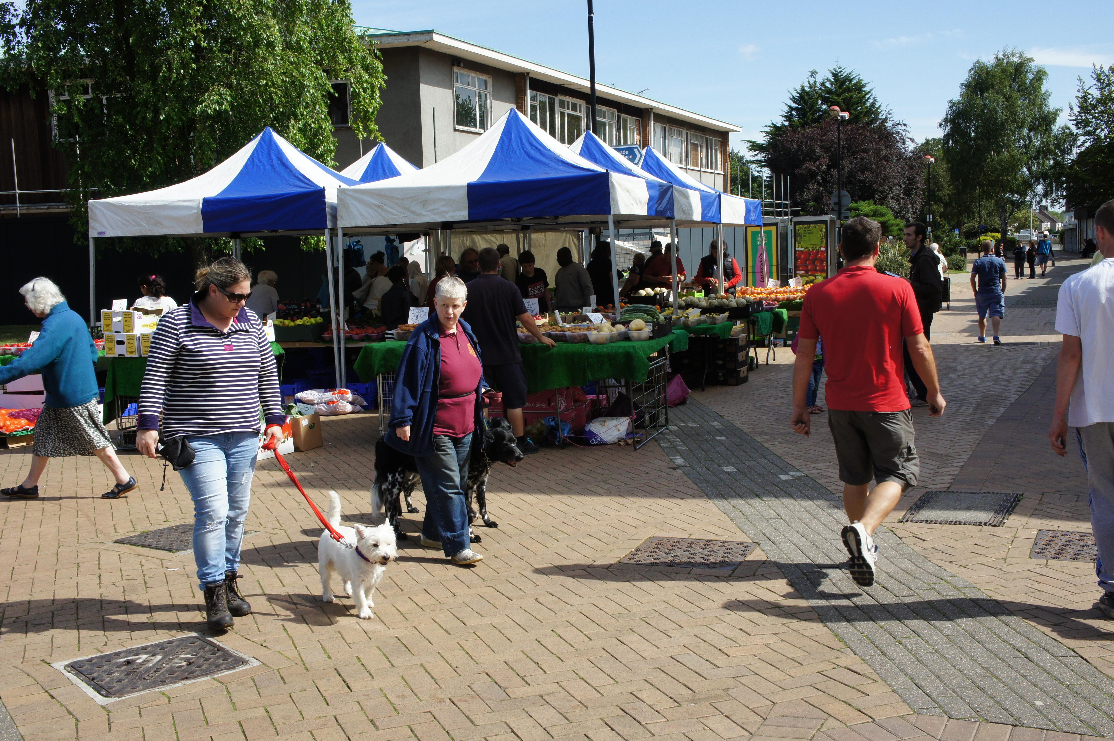 People walking past market stalls in Hatfield town centre.