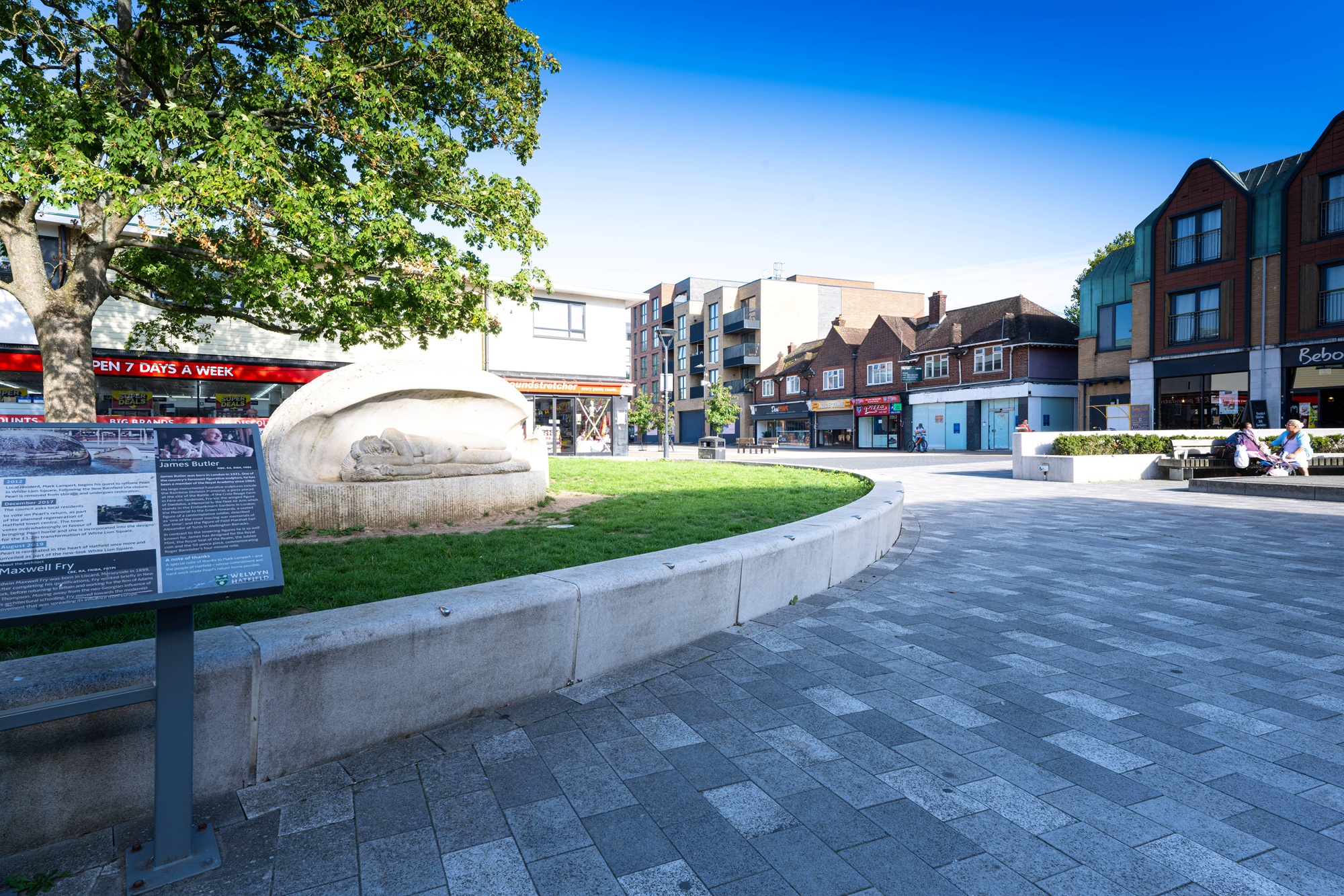 Pedestrianised area of Hatfield town centre with stone statue and tree