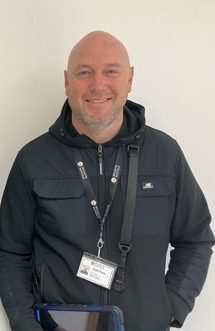 Man wearing lanyard, smiling